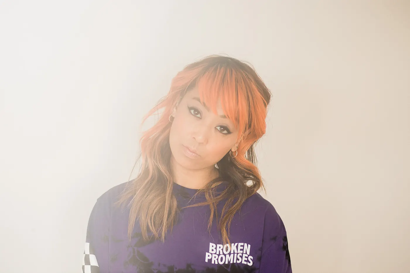 Soft, hazy portrait of Cell7 with orange hair tilting her head